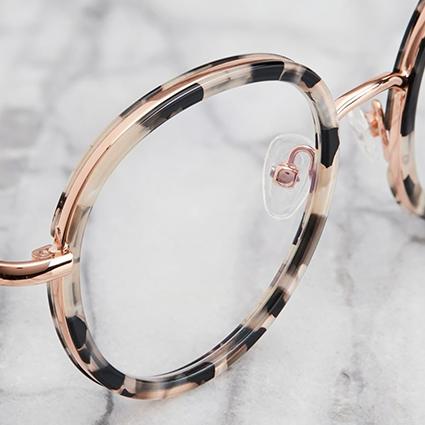 Round tortoiseshell eyeglasses with clear nose pads.