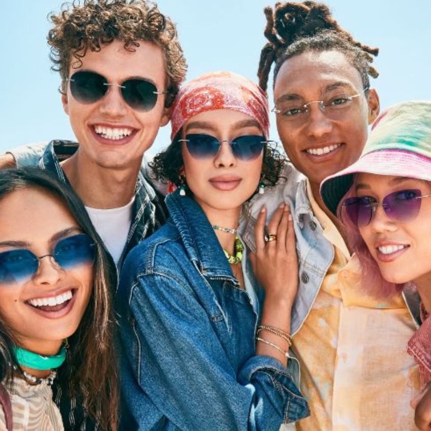Group of friends wearing various styles of sunglasses outdoors on a sunny day.